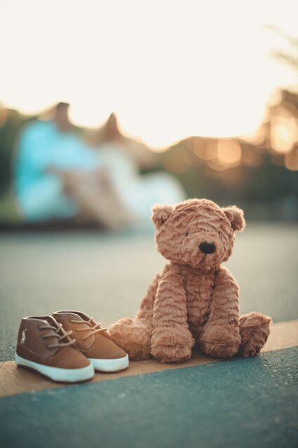 Ours Brun En Peluche à Côté D'une Paire De Chaussures Marron Et Blanc Pour Tout Petit Sur Le Sol En Photographie Mise Au Point Sélective